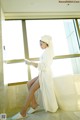 A woman in a bathrobe sitting on a bathtub reading a book.