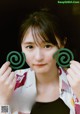 A woman holding two green spirals in front of her face.