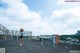 A woman standing on top of a roof with her arms outstretched.