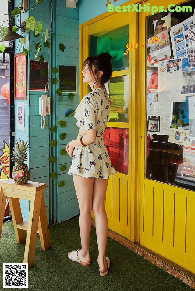 A woman standing in front of a yellow door.