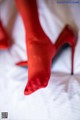 A pair of red high heels on a bed.