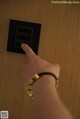 A person is pressing a button on a wooden door.