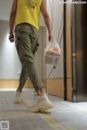 A man in a yellow shirt is walking down an elevator.