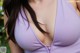 A close up of a woman wearing a purple bra.