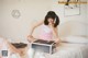 A woman sitting on top of a bed next to a box.