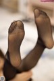 A close up of a woman's legs in black stockings.