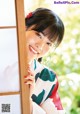 A woman in a kimono leaning against a window.