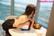 A woman sitting at a table with a bowl of fruit.