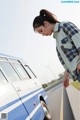 A woman standing next to a blue and white van.