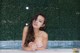 A woman in a white bikini sitting in a pool.