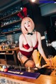 A woman in a red lingerie sitting at a bar.