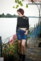 A woman standing on a wooden deck next to a body of water.